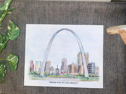Illustration of the Gateway Arch in St. Louis, Missouri on a textured surface with leaves.